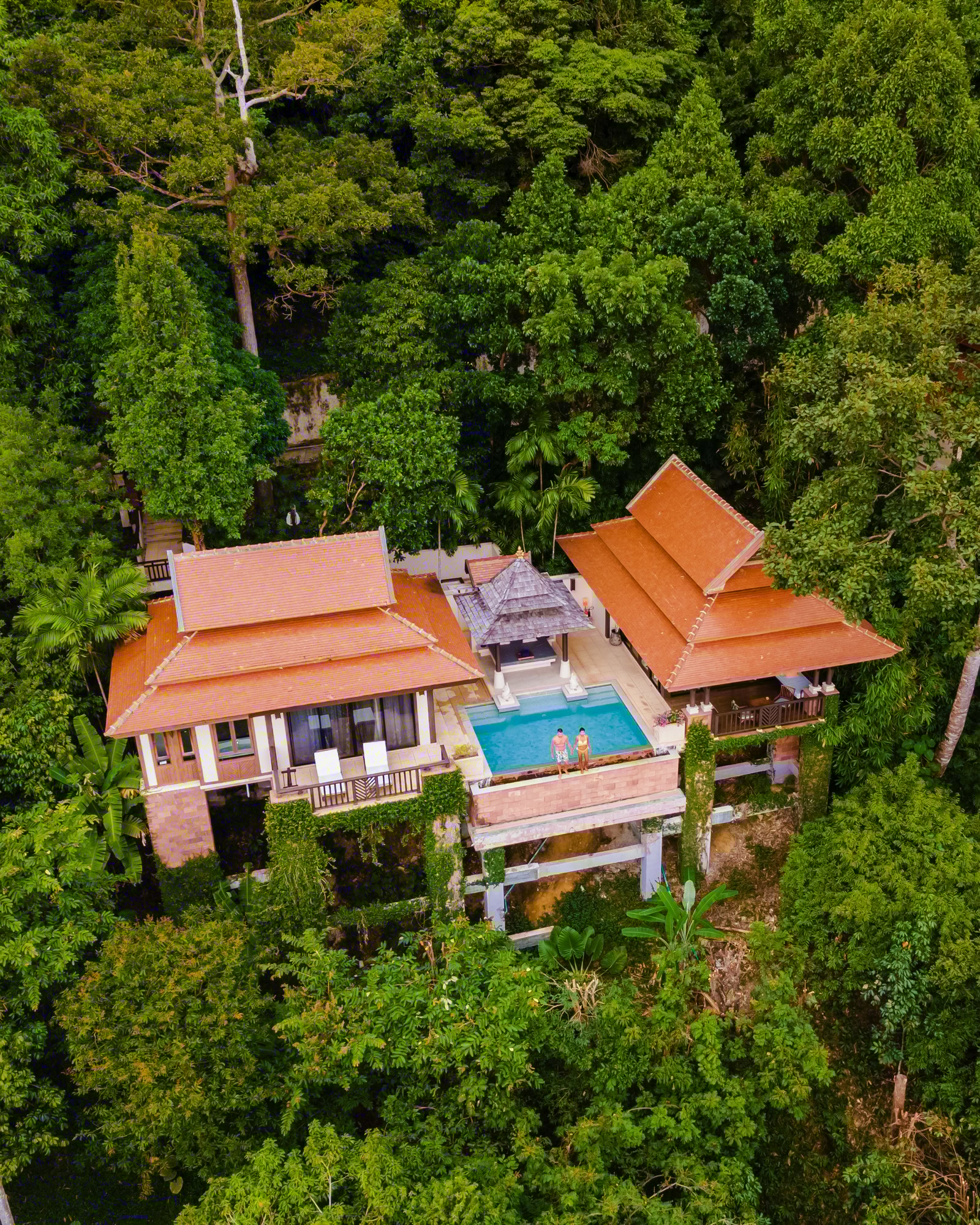 couple of men and woman on a luxury vacation at a pool villa in the jungle rainforest